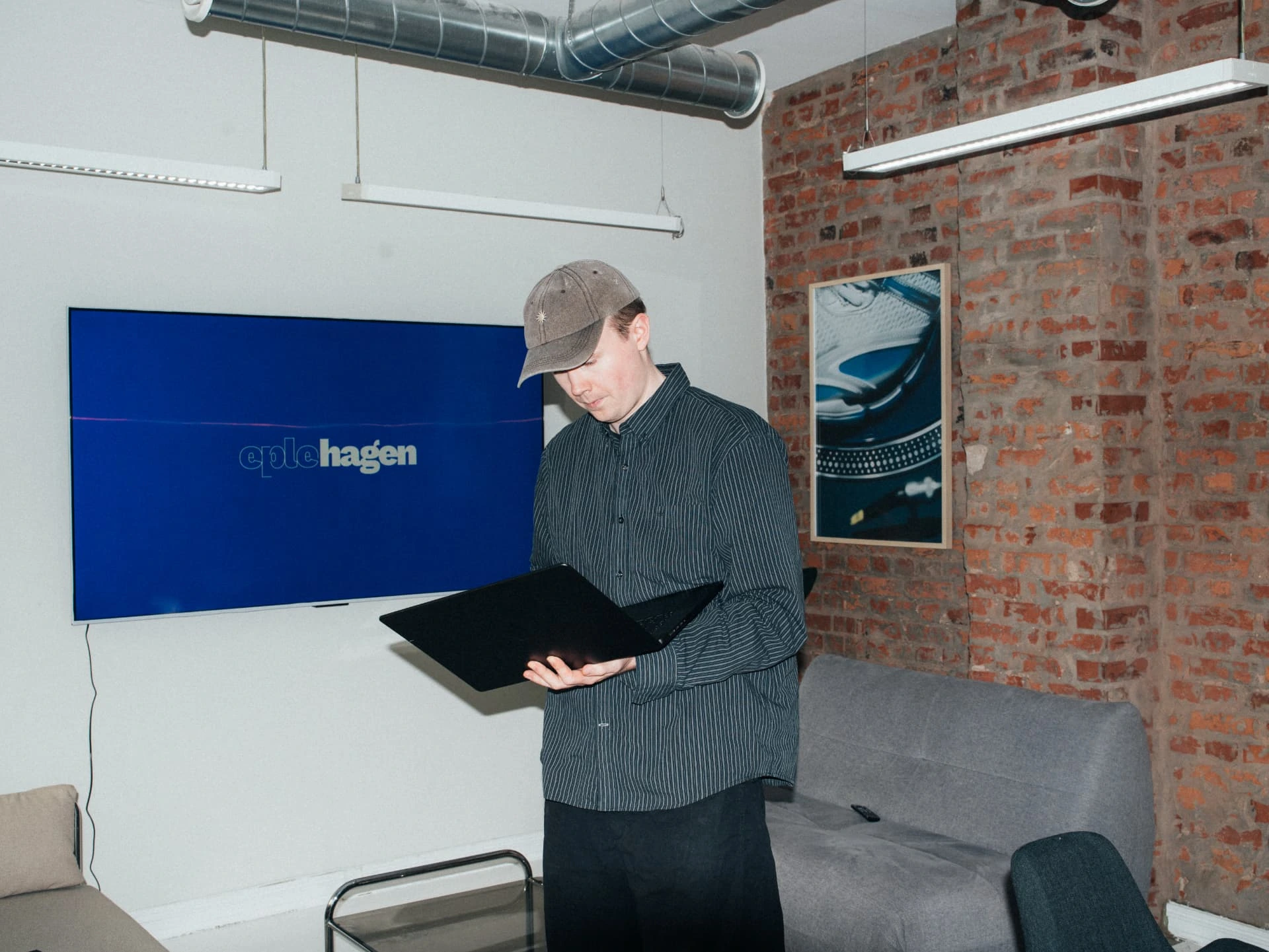 Eplehagen i studioet med laptop foran skjermen med eplehagen-logoen